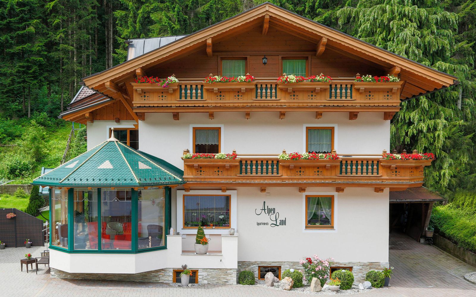 Alpenland Appartements in der Wildschönau mit Holzbalkonen und Blumenschmuck