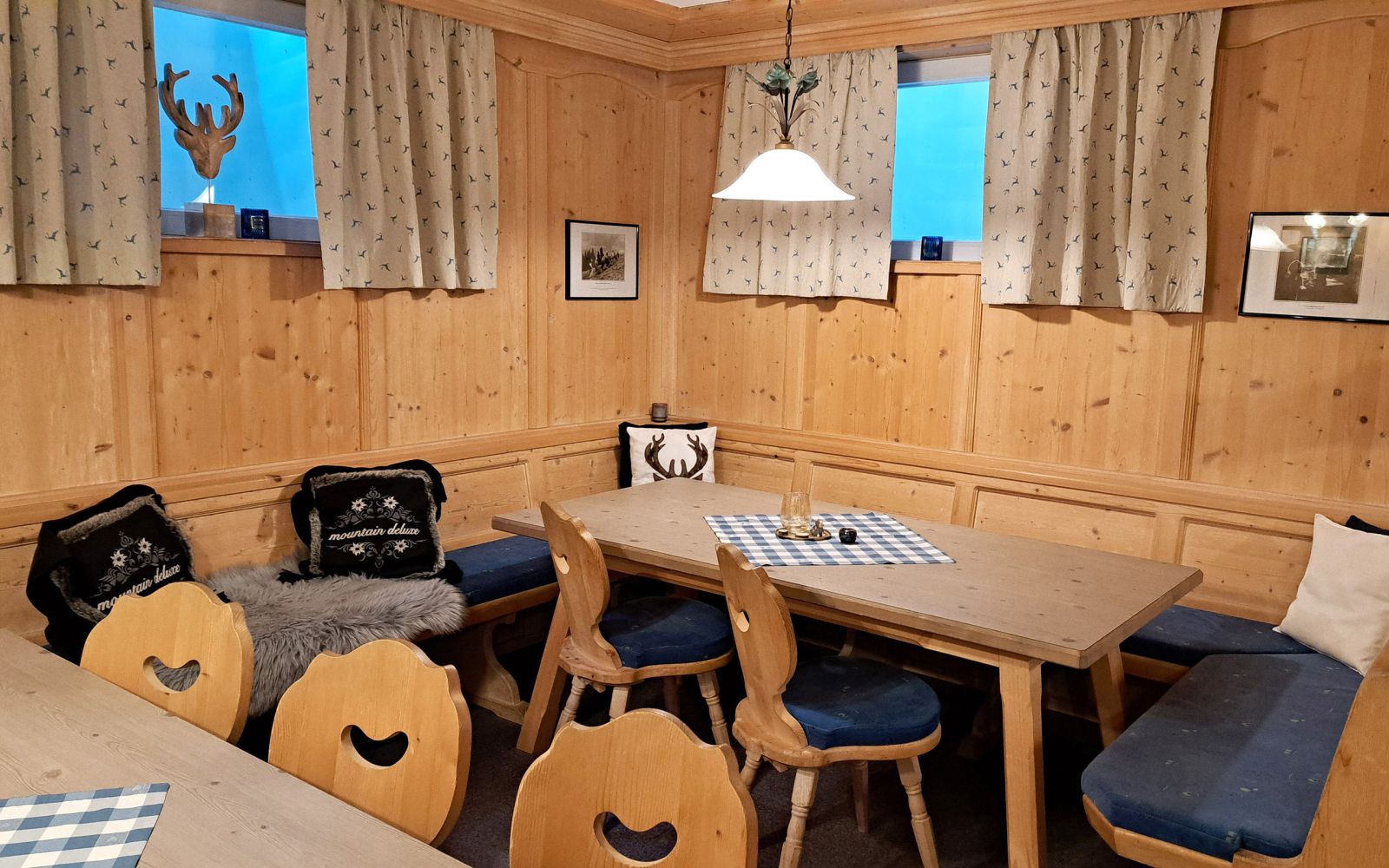 Gemütlicher Aufenthaltsraum mit Holzvertäfelung und Sitzecke in den Alpenland Appartements