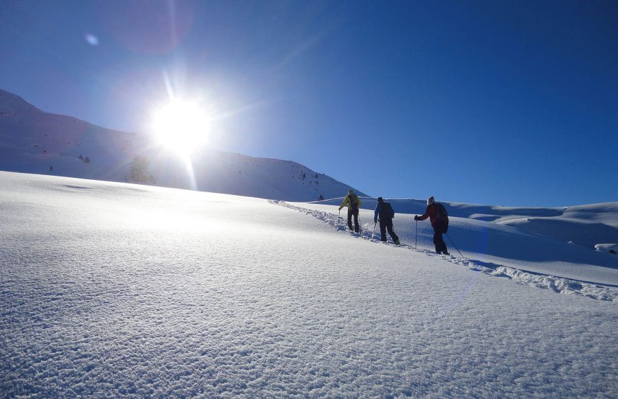 Gruppe bei einer Schneeschuhwanderung durch tief verschneite Winterlandschaft