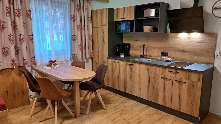 Küche mit Essbereich im Appartement Gratlspitz in warmer Holzoptik