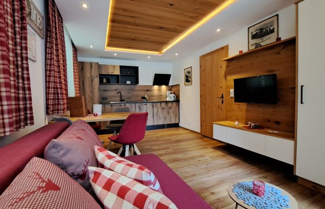 Wohnbereich im Appartement Feldalphorn mit Sofa, Essecke, Küche und TV