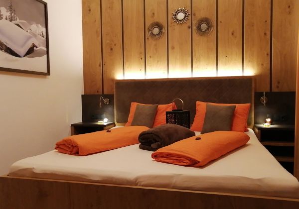 Gemütliches Schlafzimmer im Appartement Schönangeralm mit Doppelbett und warmem Holzambiente