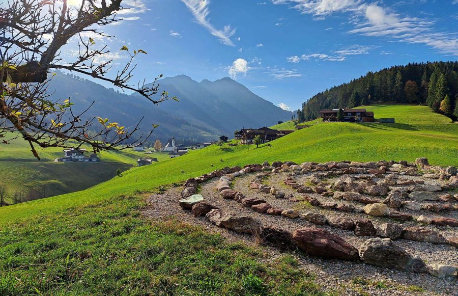 Blick über grüne Wiesen und Bauernhöfe auf ein Dorf in der Wildschönau